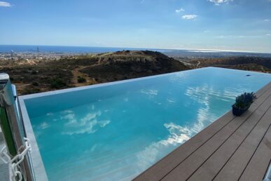 Infinity swimming pool overlooking the sea and coastal landscape